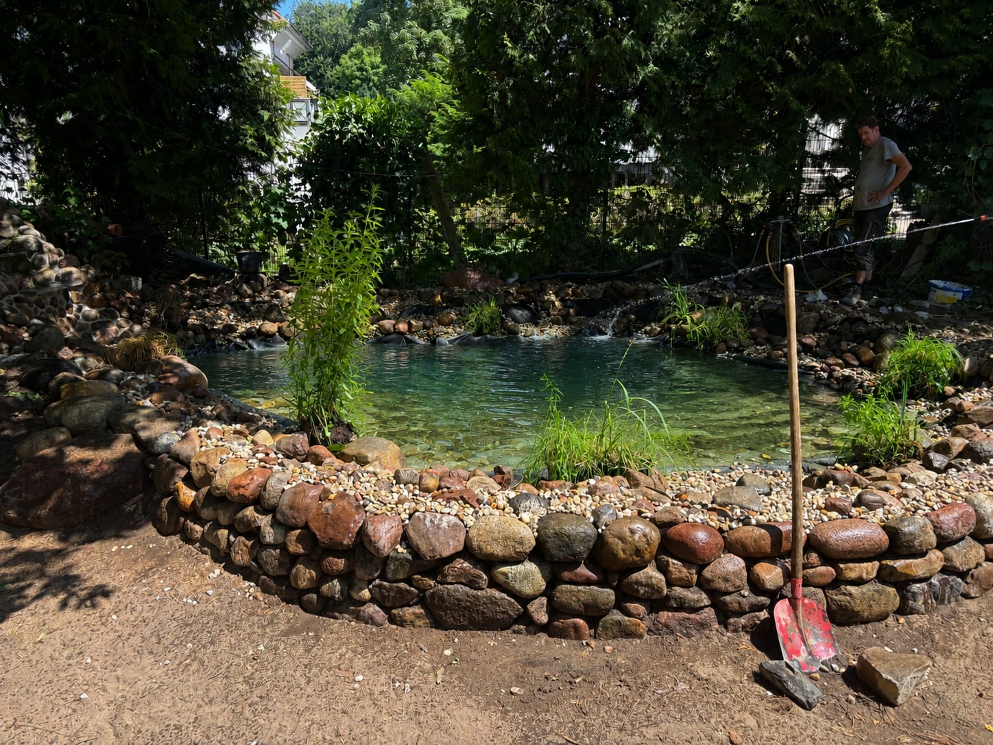 Naturnaher Schwimmteich mit Natursteinrand und Bepflanzung
